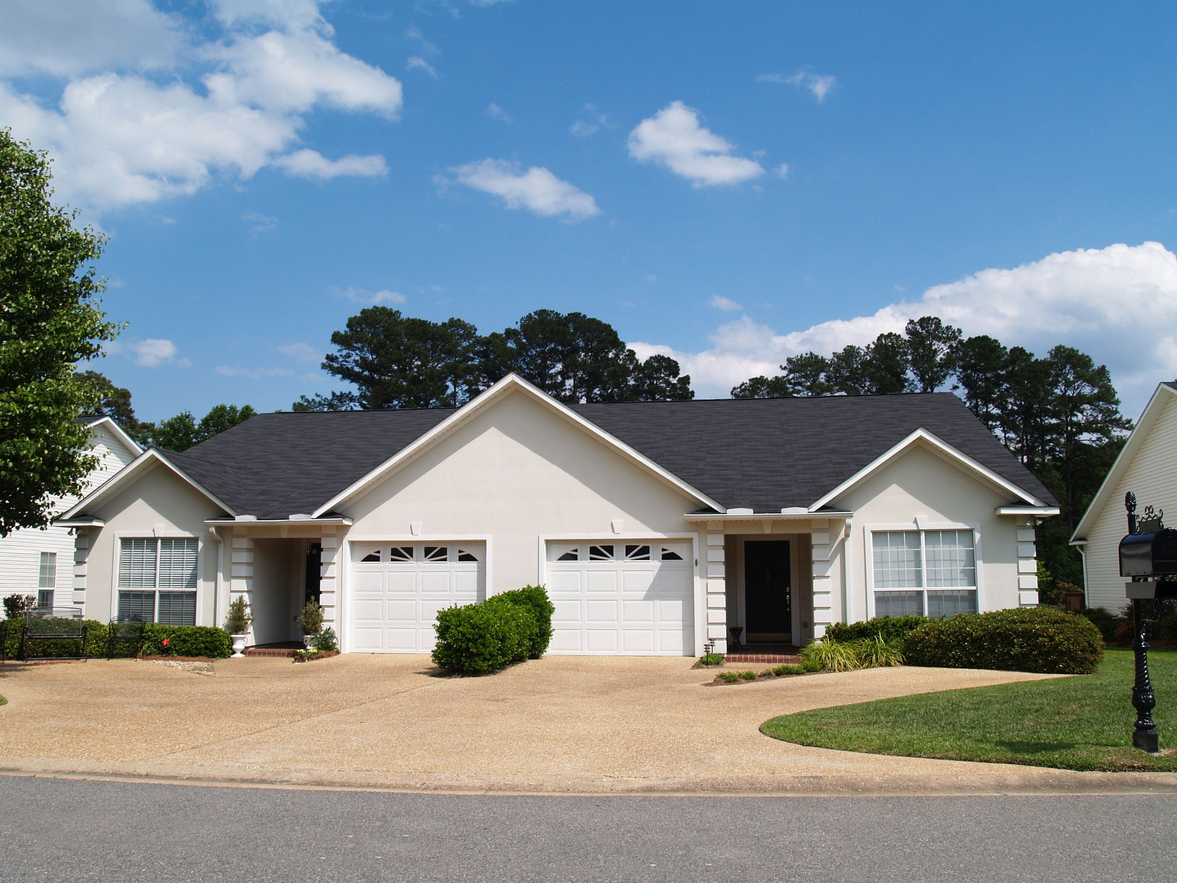 A clean white house with a black roof, symbolizing a desirable property in Florida, potentially featured in a property lien search guide.